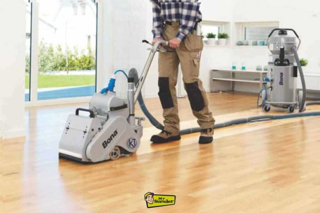 A professional sanding a light oak wooden floor in a modern, bright living space in Hampton Hill using advanced Bona floor sanding equipment, showcasing floor restoration by Mr. Sander.