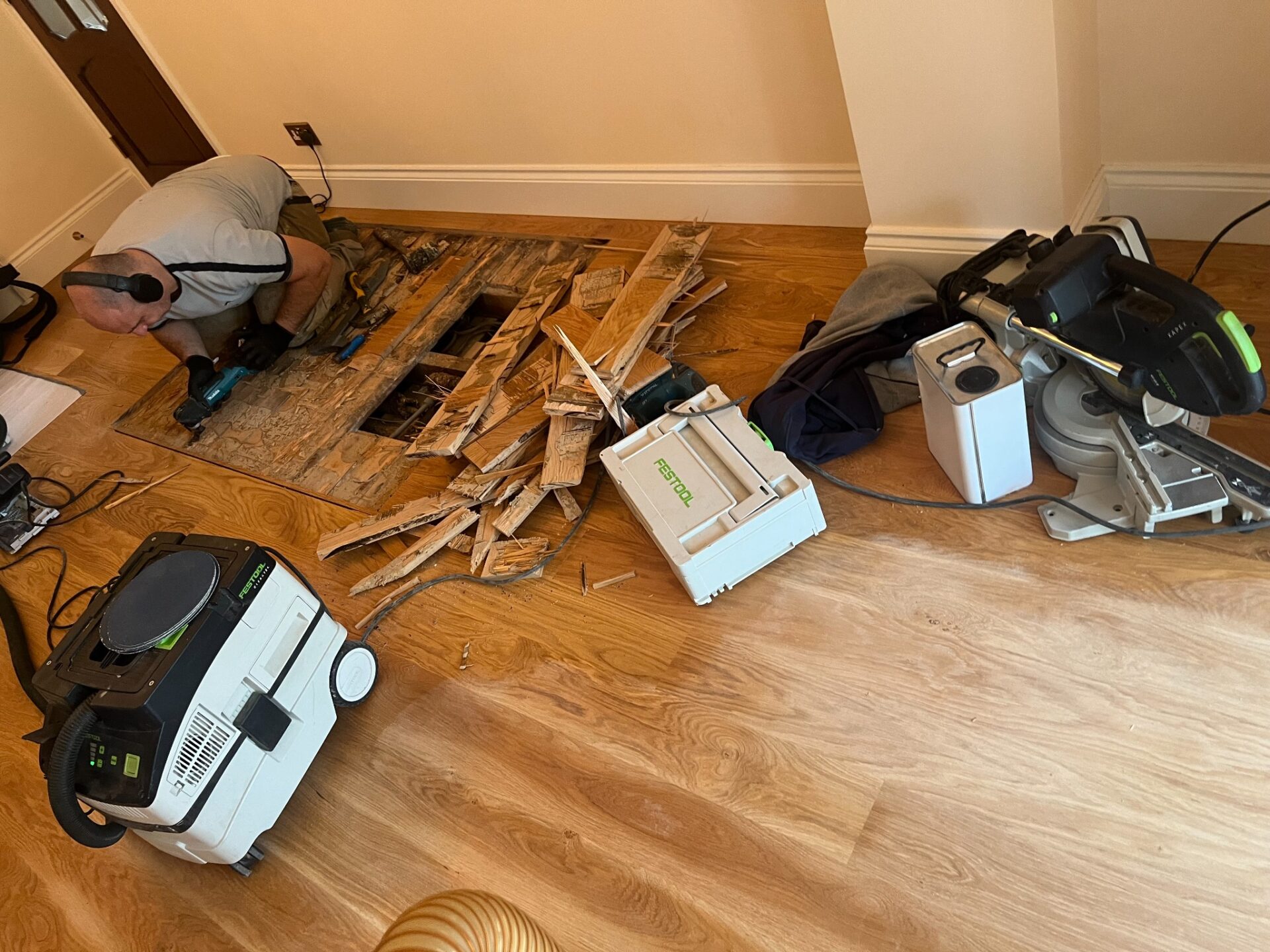An Overview of Wood Floor Sanding with subfloor repair before sanding; technician replacing damaged boards and prepping area