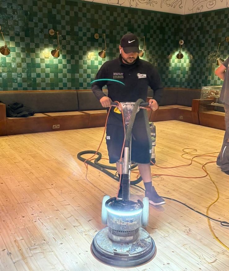 Floor-sanding technician using a powerful rotary machine on a pale timber floor, showing the right technique to avoid Common Floor Sanding Mistakes
