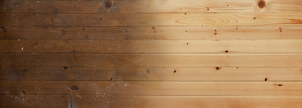 A side-by-side comparison of a wooden floor, with the left side showing a darker, worn-out, and dirty surface, while the right side displays a lighter, freshly sanded, and clean wooden surface. The contrast highlights the difference between an untreated and a sanded floor.