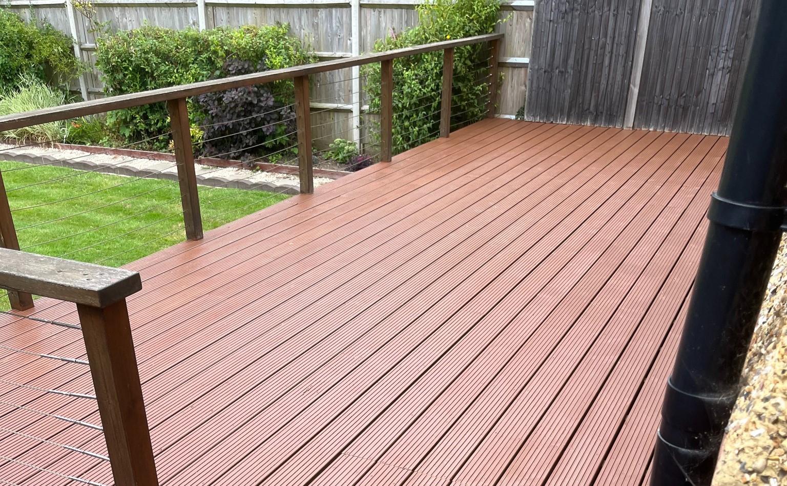 Deck Sanding and Oiling on grooved softwood timber decking, showing a freshly refinished garden deck with a smooth, even stain and clean balustrade.