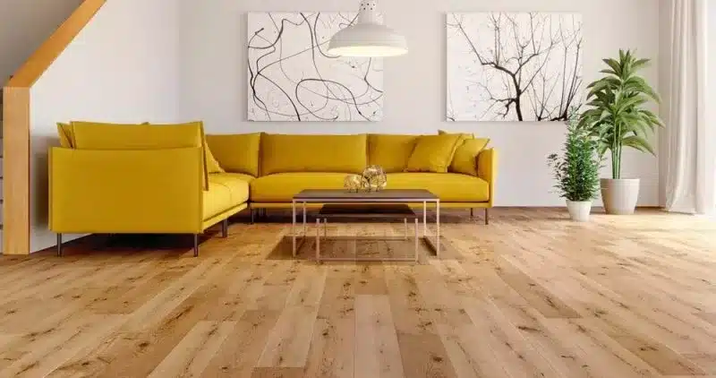 Modern living room with a vibrant yellow sectional sofa, hardwood flooring, and minimalist decor.
