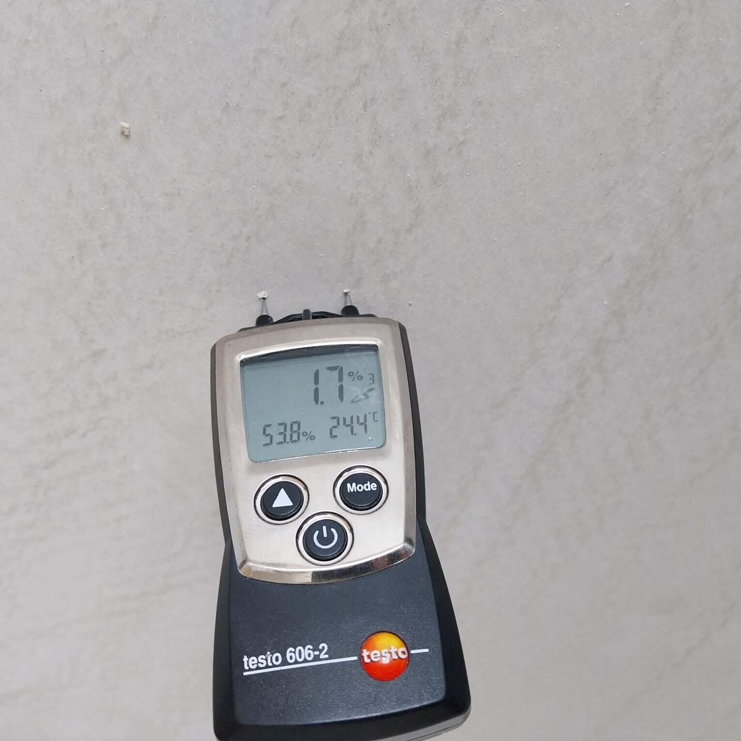 Moisture meter reading on a screed subfloor—evidence to follow the rule Donot Fit Over a Wet Screed before laying an oak parquet engineered wood floor.