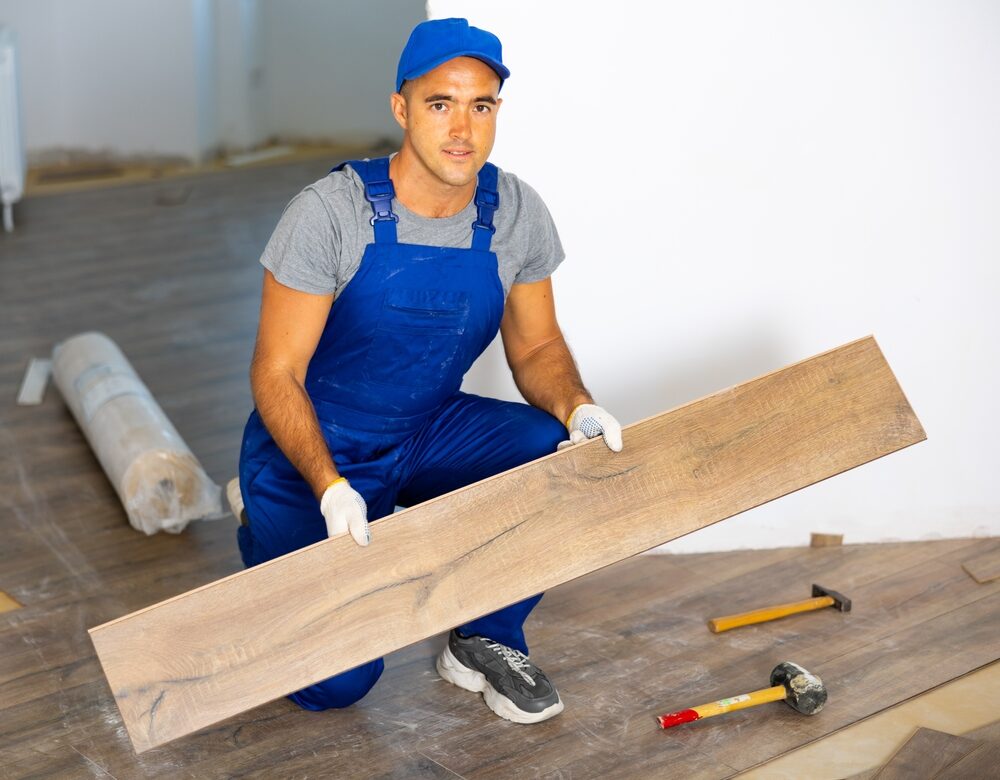 Professional installer fitting wooden planks during Engineered Floor Installation of oak wood flooring.