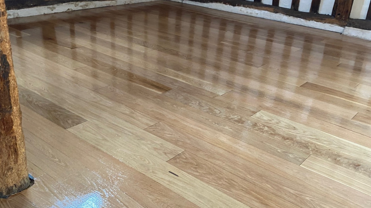 Freshly finished oak engineered wood floor after Engineered Floor Restoration, showing smooth, glossy boards with a rich natural grain.