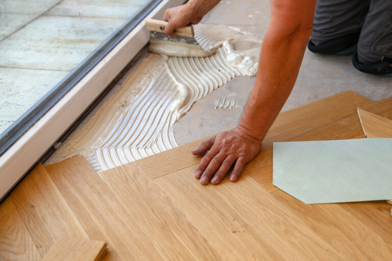 Floor Installation for Allergens – Mr Sander® fitter securing oak herringbone parquet blocks over a bed of low-VOC adhesive for a hypoallergenic finish