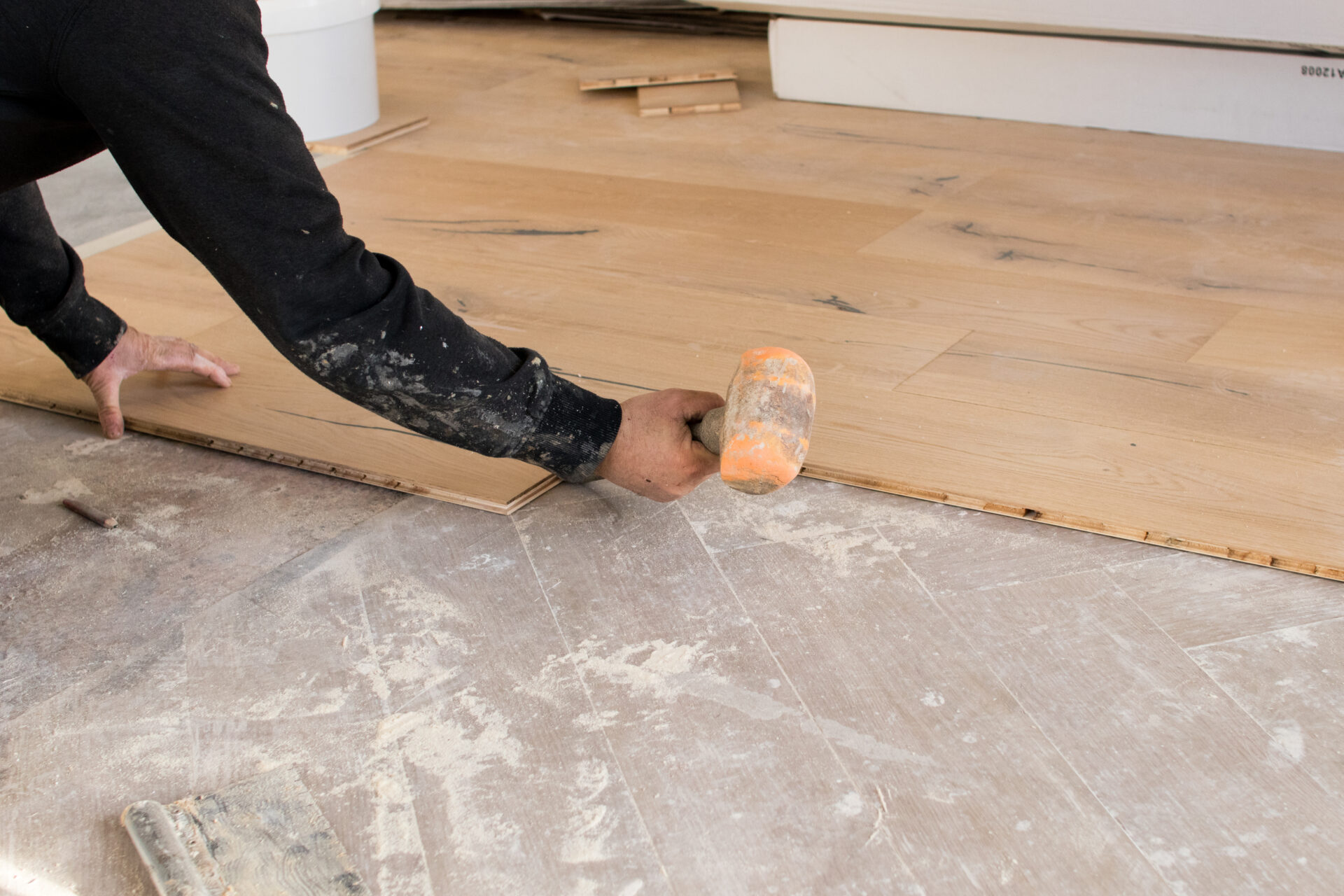 Floor Installation for Allergens – Mr Sander® fitter tapping wide engineered oak planks with a rubber mallet for a tight, hypoallergenic fit