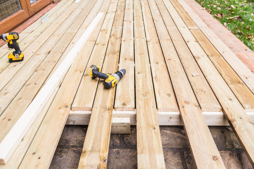 Grooved boards being fixed to joists during Floor Installation for Swimming Pools with cordless tools
