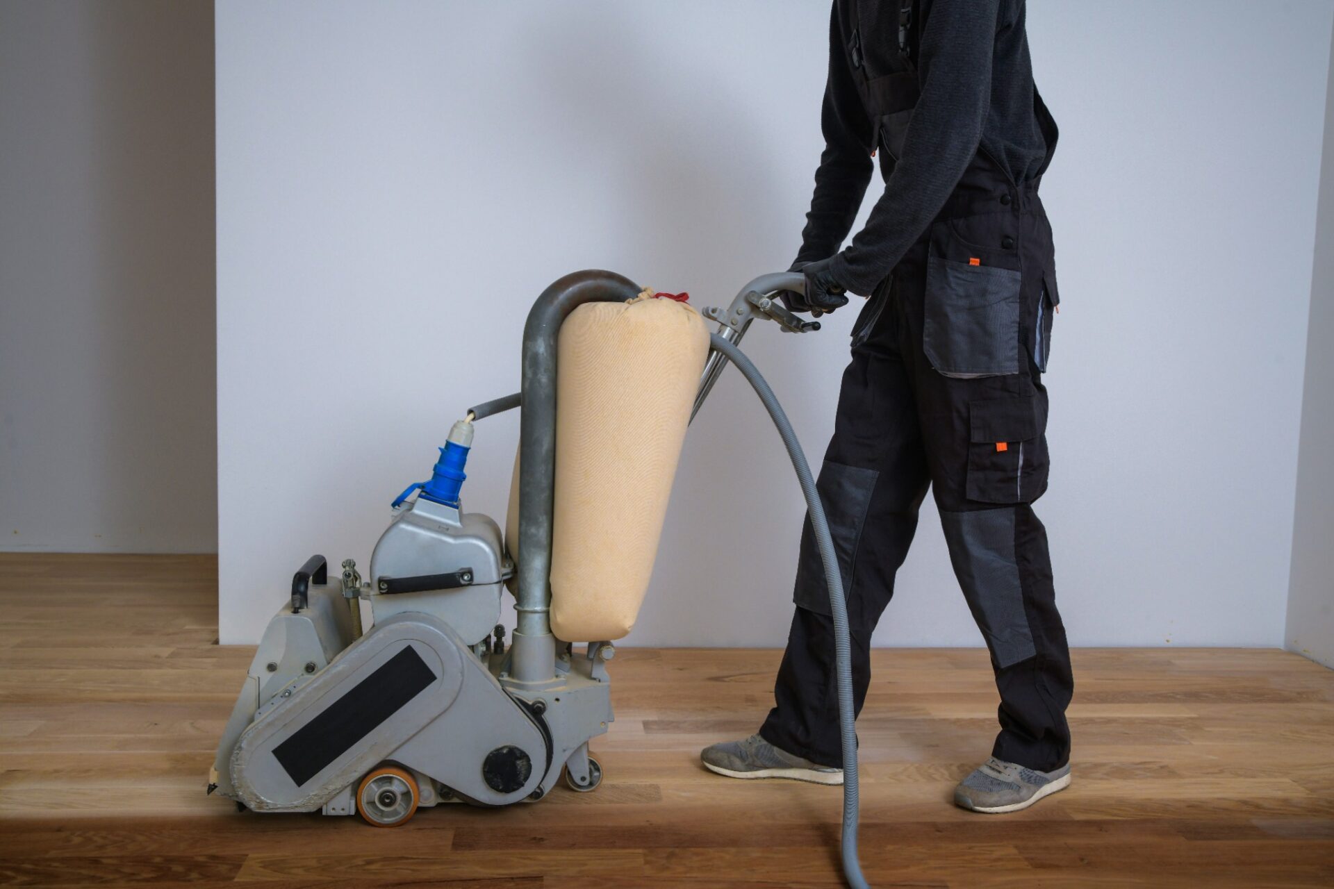 Technician using a dustless floor sanding machine on an oak plank floor as part of Mr Sander®’s Floor Sanding and Satin Finishes service.