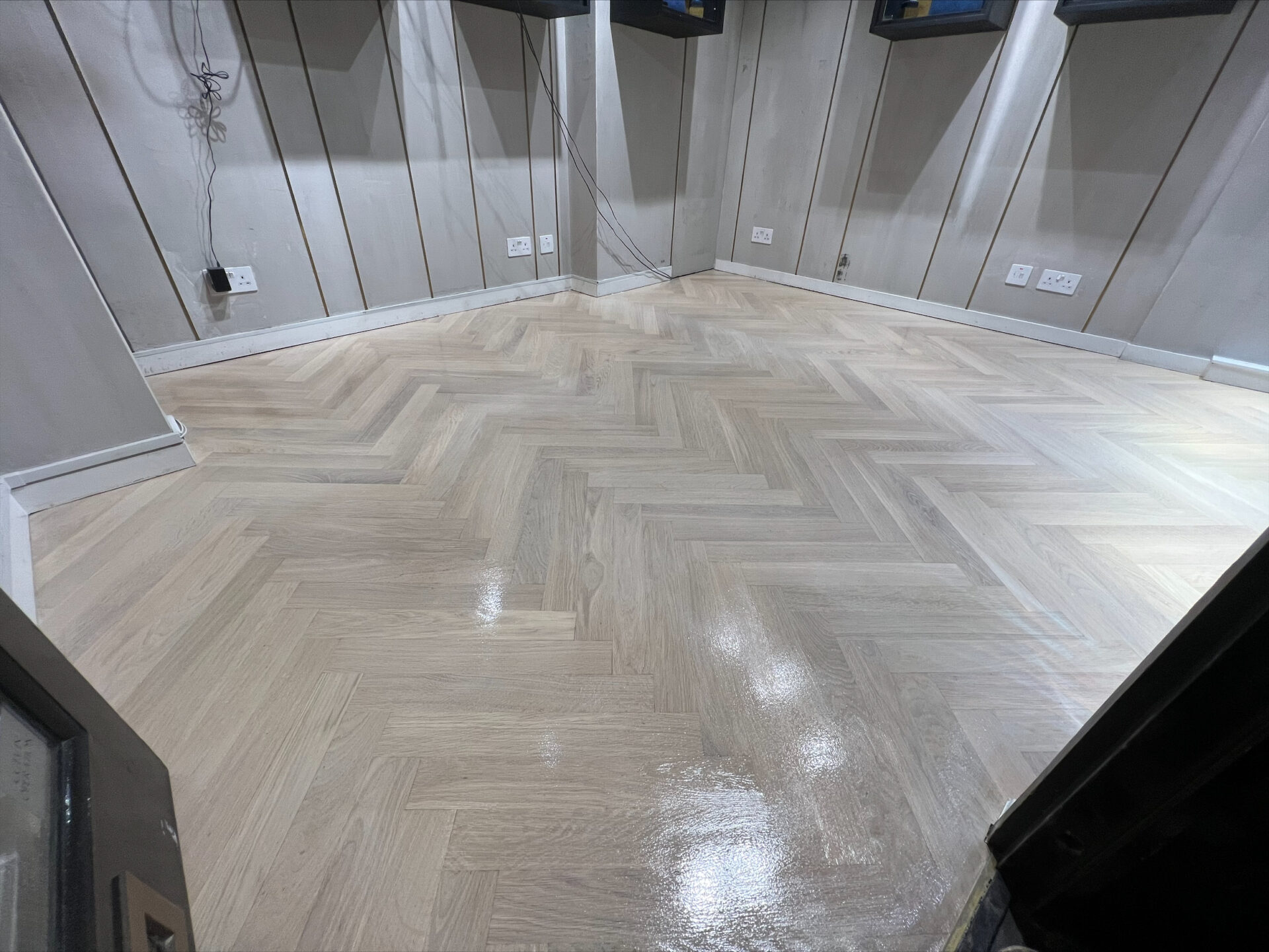 Freshly restored herringbone oak parquet floor after Floor Sanding in Retail Spaces by Mr Sander, showing a smooth, satin finish in a boutique.