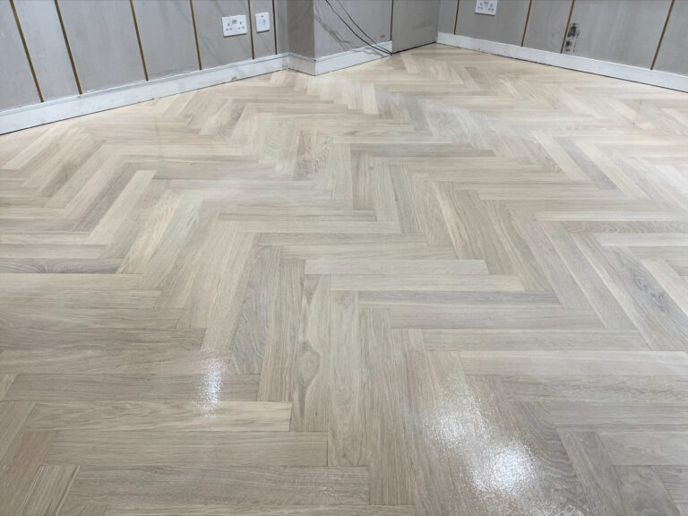 Flawless herringbone oak parquet floor after Floor Sanding in Retail Spaces by Mr Sander, gleaming with a uniform satin finish.