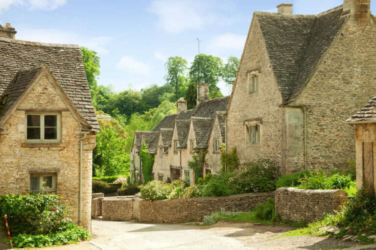 Floor Sanding in Rural Homes – traditional stone cottages with steep‑pitched slate roofs lining a quiet country lane, evoking the need for careful heritage floor restoration.
