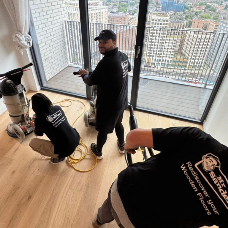 Mr Sander team practising Floor Sanding Safety with dustless sanding and HEPA extraction on a light oak floor in a high-rise apartment.