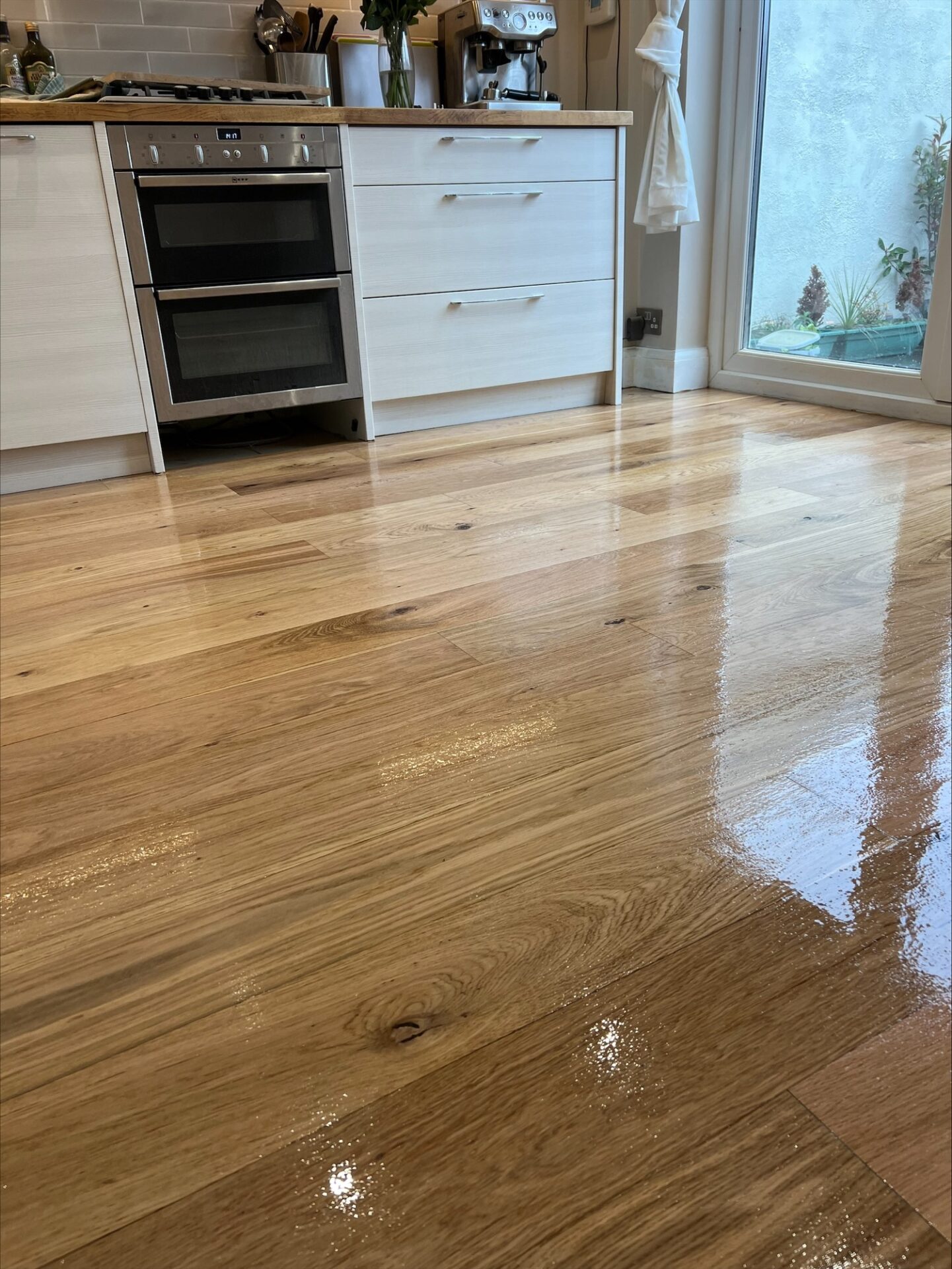 Close-up of a newly sanded and lacquered oak kitchen floor in a UK city apartment — a hallmark of Floor Sanding in Urban Apartments.