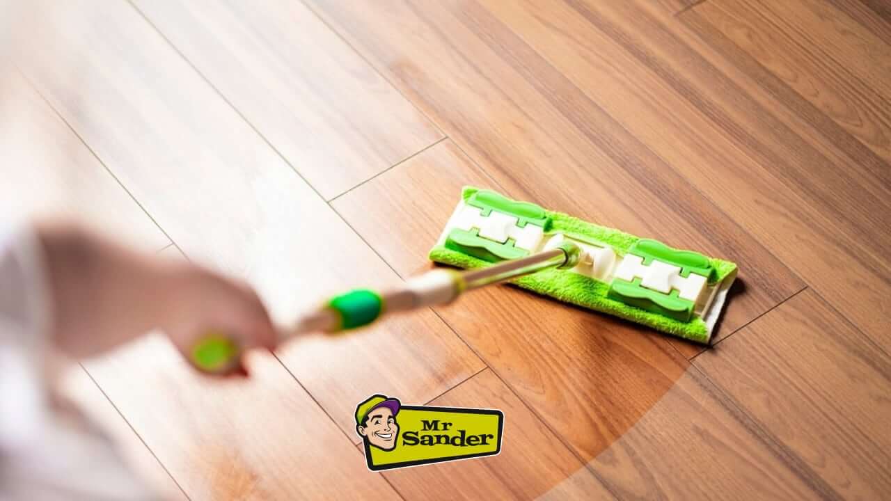 A person mopping a newly refinished wooden floor.