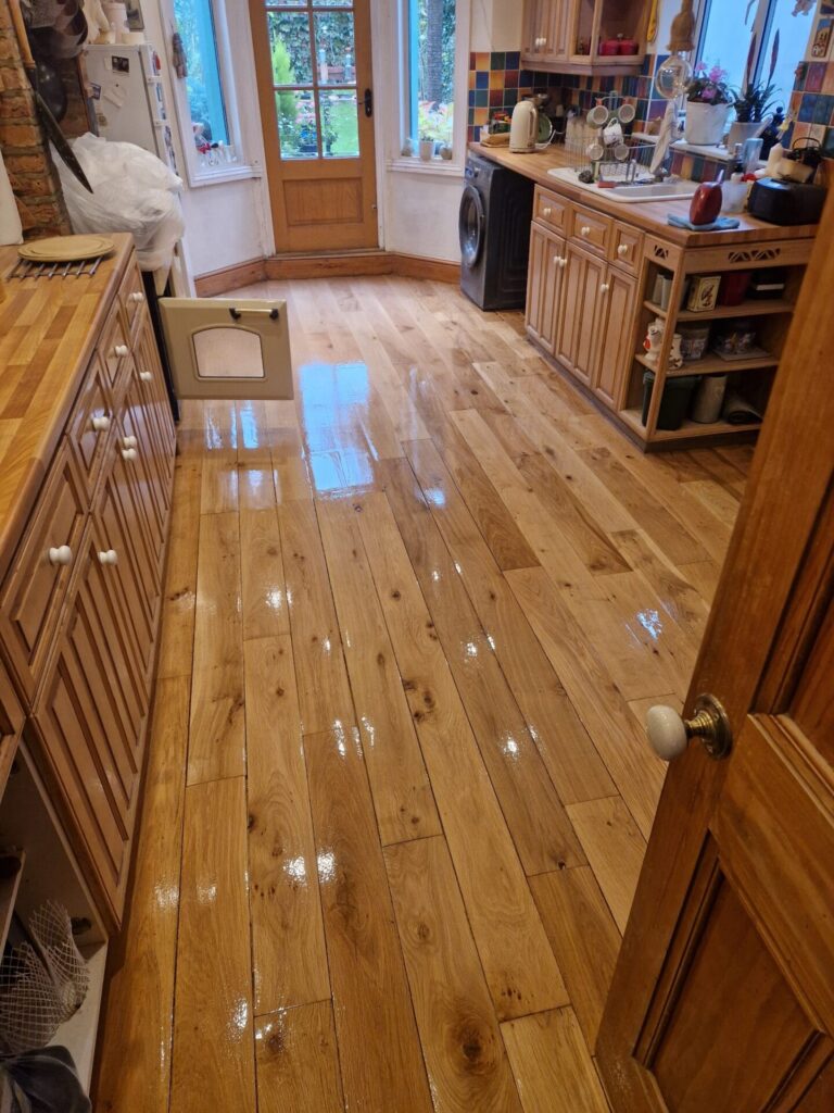 Freshly restored oak hardwood floor in a London kitchen, showing a smooth, glossy finish after professional sanding and polishing by Mr Sander.