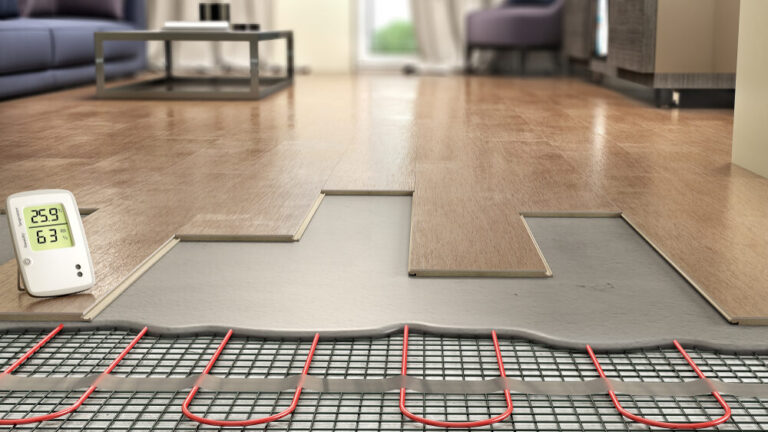 Cut-away view of engineered oak flooring being laid over an electric underfloor heating mesh, illustrating safe Heating and Floor Installation with a digital thermostat reading 25.9 °C and 63 % humidity.