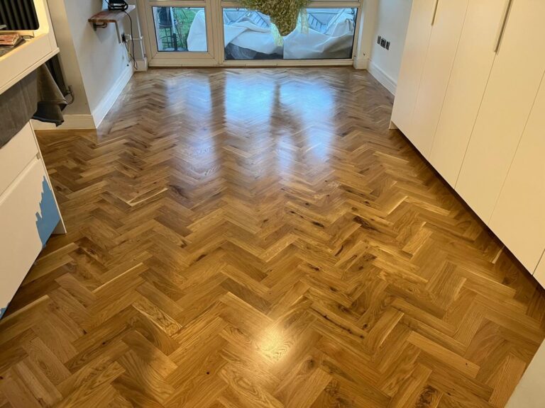 Freshly finished oak herringbone parquet wood floor in a bright modern room, showing smooth, even pattern ideal for Herringbone Hallways.