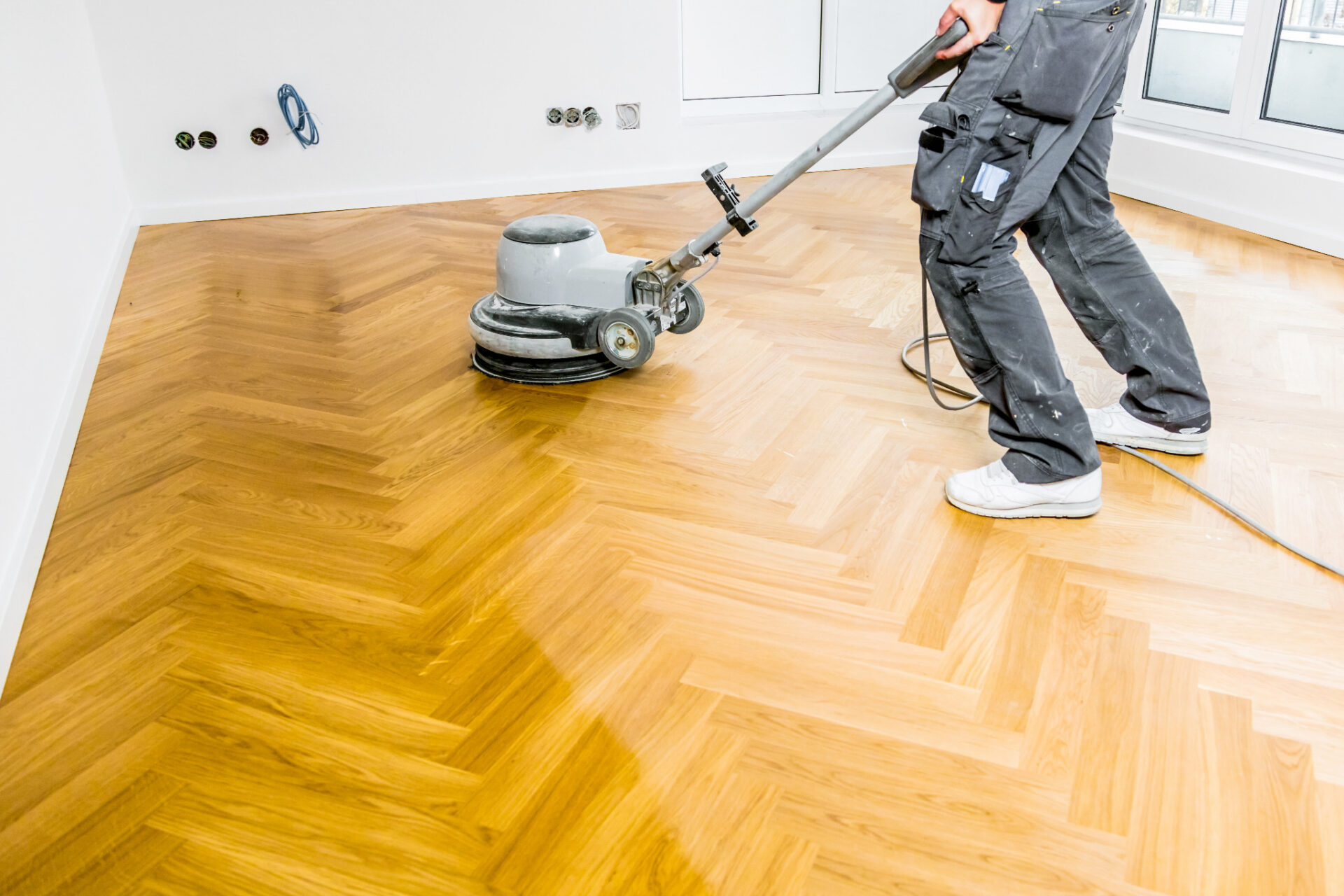 Love Your Parquet – technician buffing a freshly sanded herringbone oak parquet wood floor, evening the surface and bringing up a smooth, protective sheen. Floor Sanding Aftercare