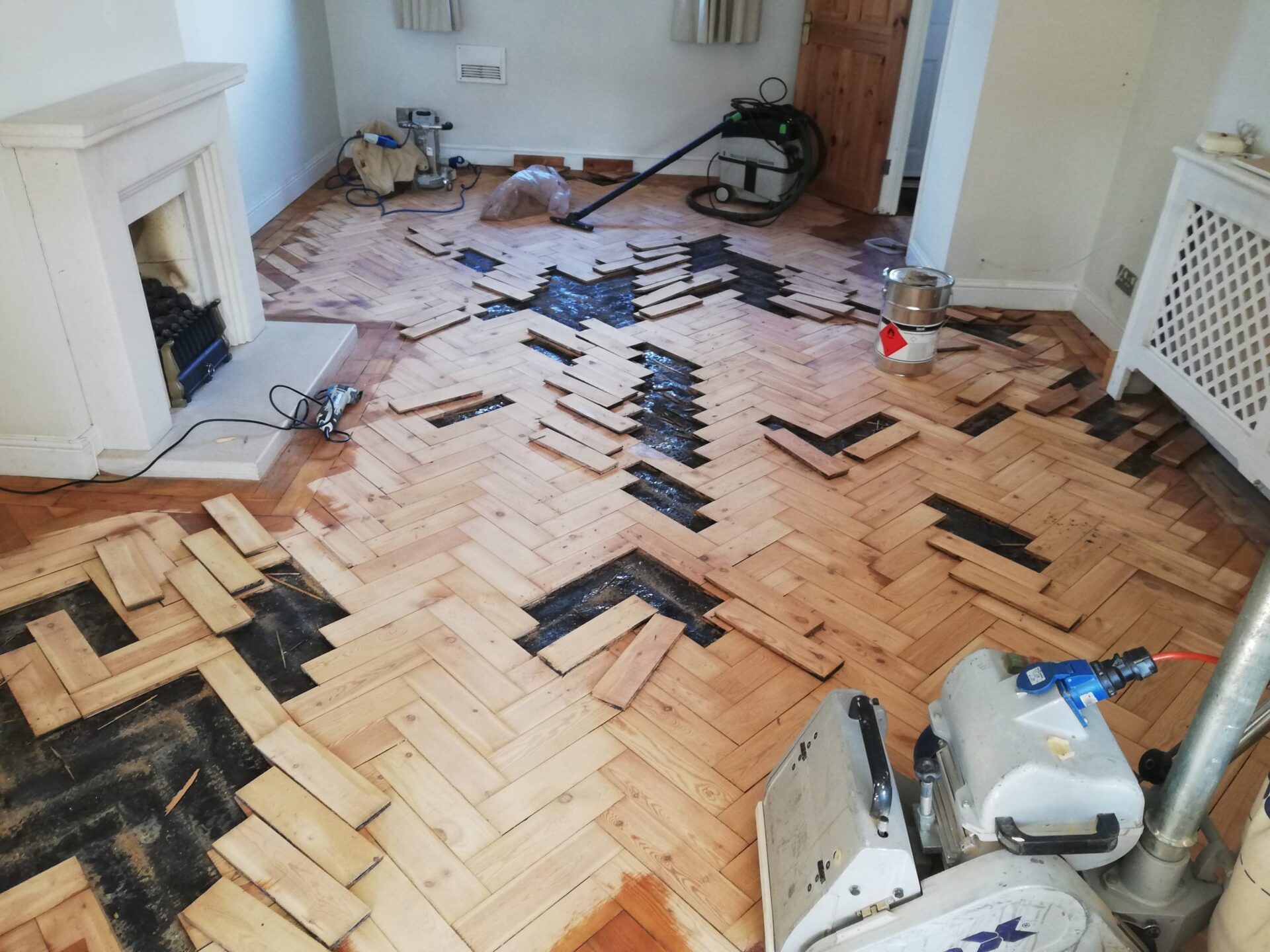 New Parquet Fitted Right with oak herringbone parquet solid wood flooring lifted for repairs and relaying over the prepared subfloor.
