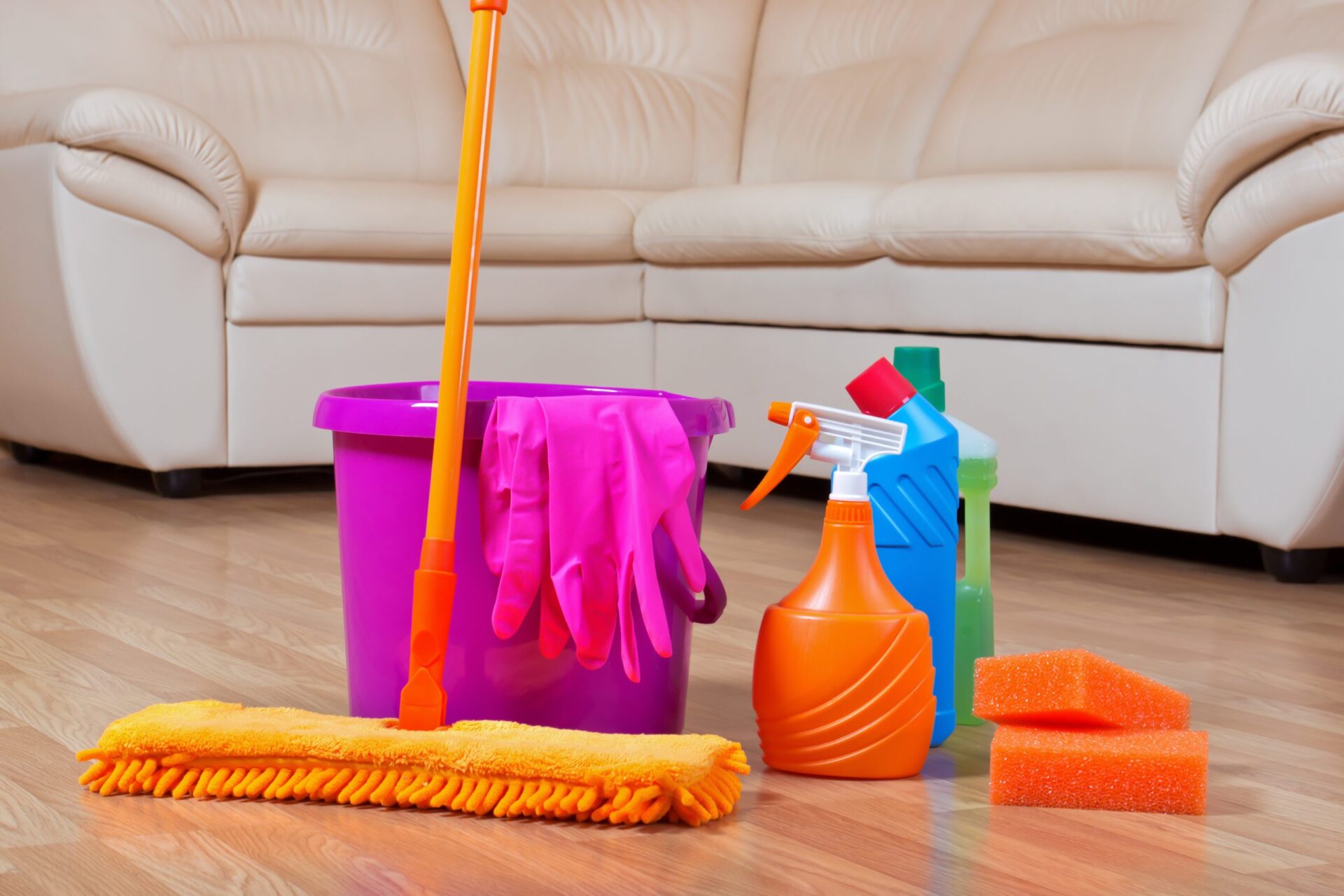 Cleaning kit on oak hardwood flooring after Sanding and Finishing—bucket, mop, gloves and neutral cleaners for safe post-finish care