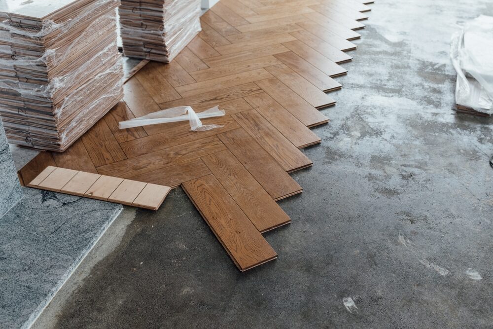 Parquet Borders framing an engineered oak herringbone parquet floor during installation, showing a clean picture-frame edge and feature strip for a custom finish.