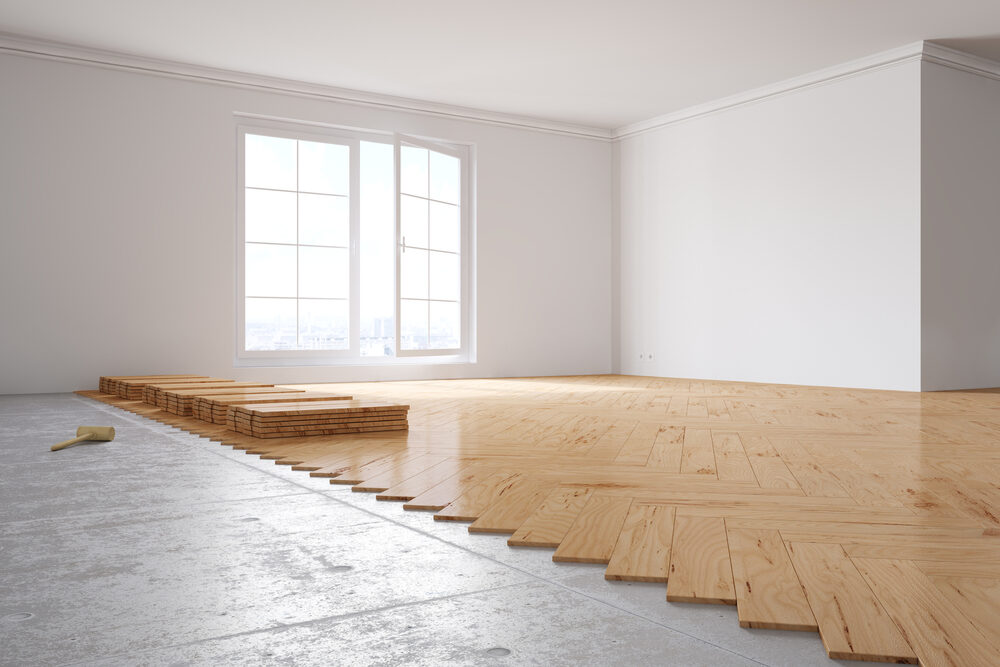 Parquet Floor Fitting in progress — solid wood herringbone over concrete subfloor mid-installation