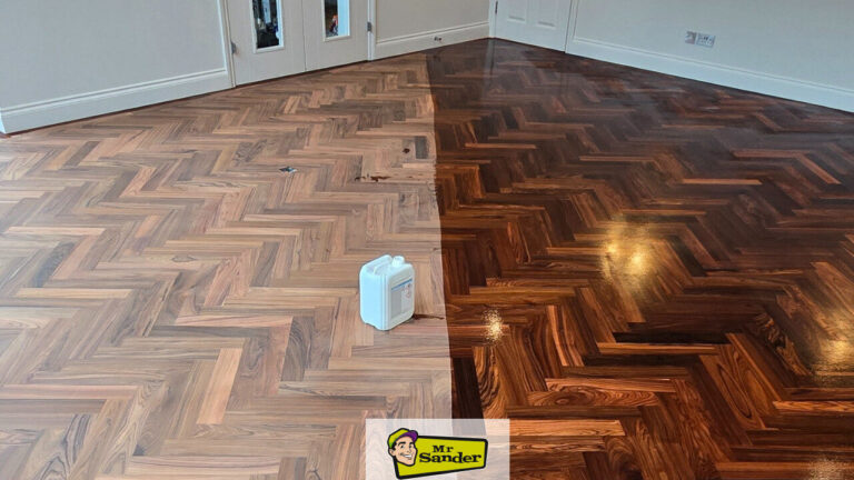 Parquet Floor Restoration — herringbone parquet half-finished, showing contrast between freshly sanded wood (left) and rich dark stained and lacquered finish (right) with applicator can visible.