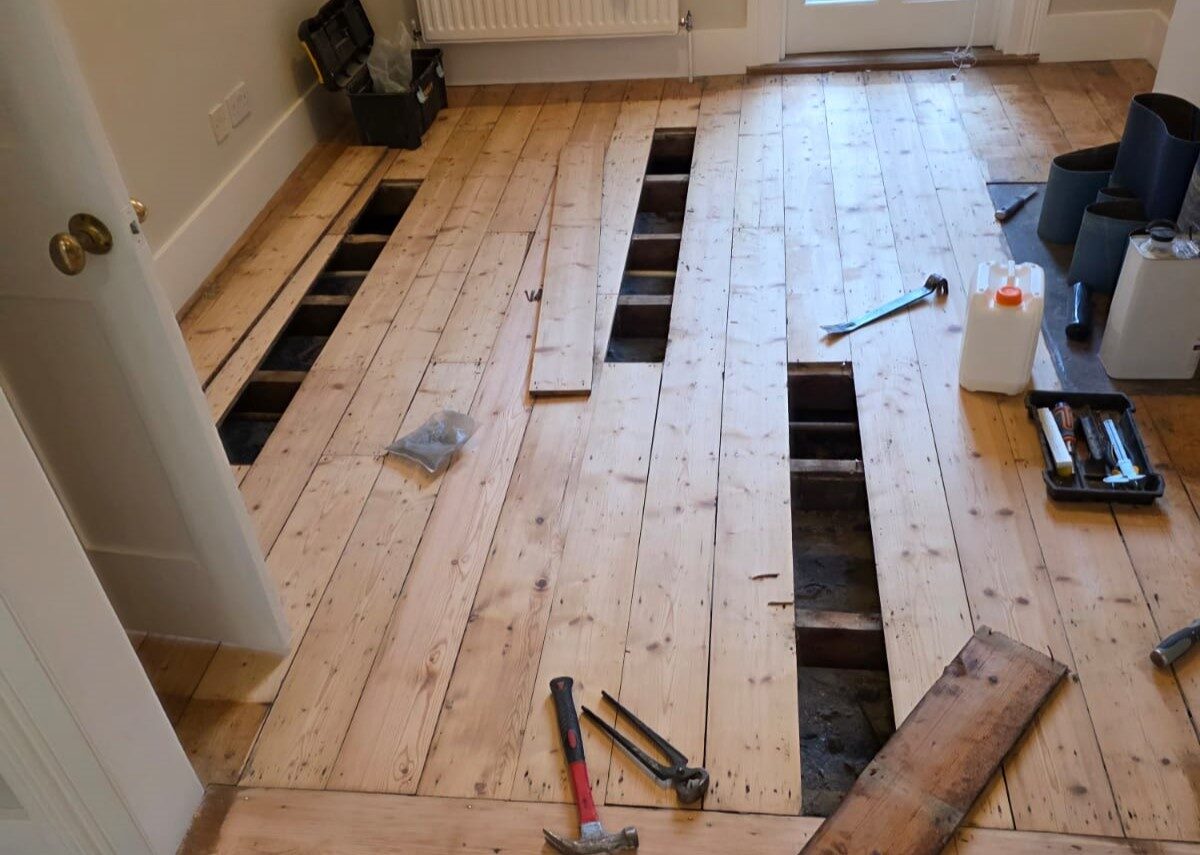 Patch Repairs Before Sanding on pine softwood floorboards, showing lifted boards and open sections being prepared for replacement before professional sanding.