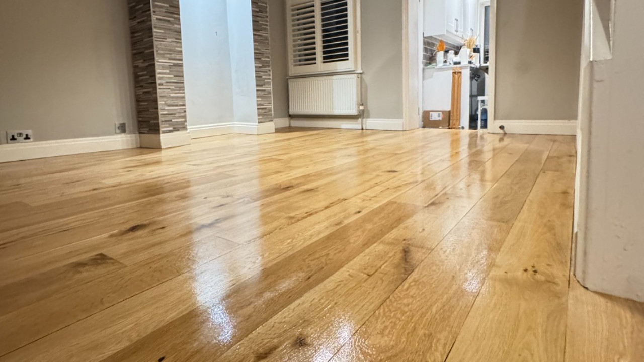 A wide-angle view of a beautifully finished wide plank engineered oak wood floor with a soft satin sheen.