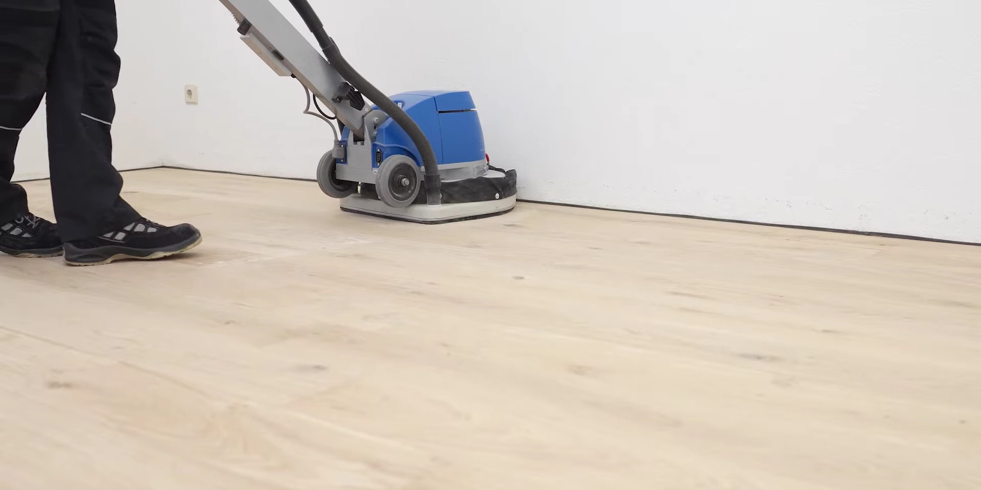 A professional floor technician using a rotary floor buffer on European Oak engineered flooring to demonstrate modern Buffing Techniques.