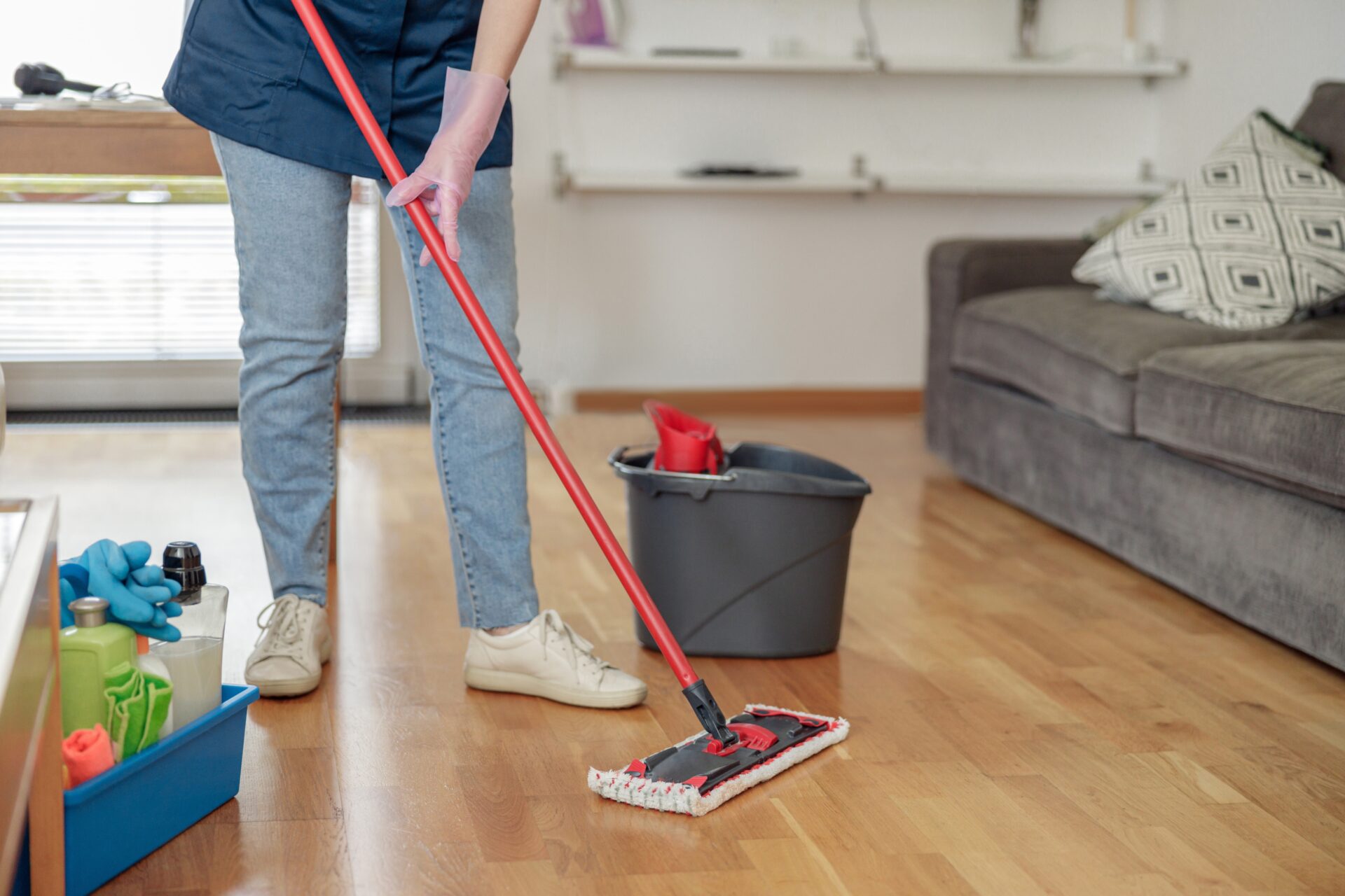 Refinish Hardwood Floors aftercare: person using a microfibre flat mop on oak plank engineered hardwood, keeping the renewed satin finish clean.