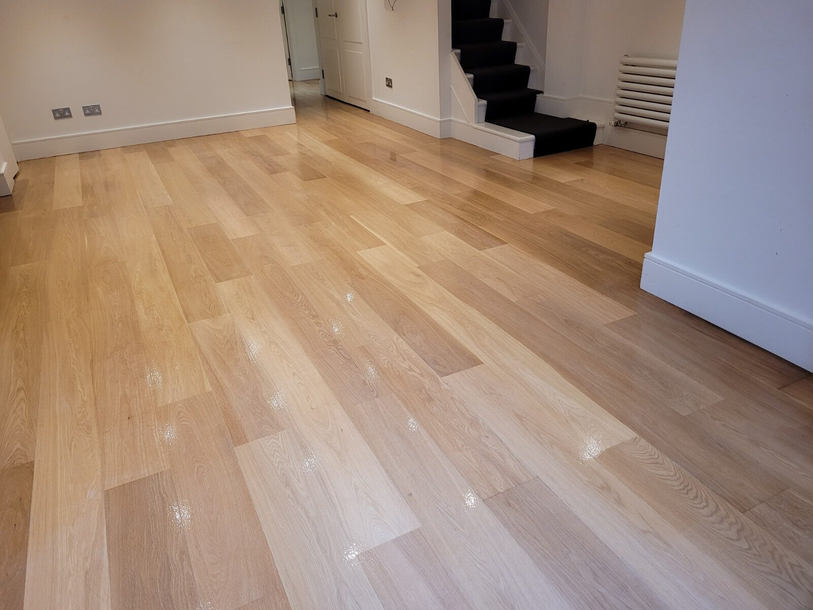 Restore Engineered Wood Floors – engineered oak plank flooring freshly sanded and refinished with a clear lacquer, giving a smooth, glossy finish and natural colour contrast.