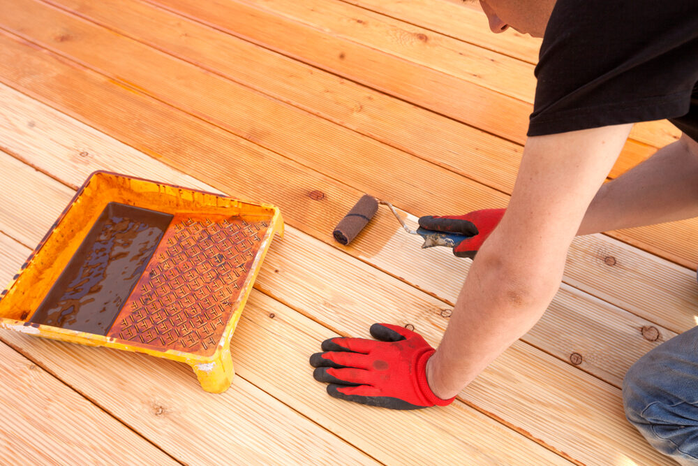 Restoring Floors in Decks: set showing grey, weathered grooved decking (before), careful orbital sanding, applying tinted oil with a roller, the finished terrace (after), and a split comparison.