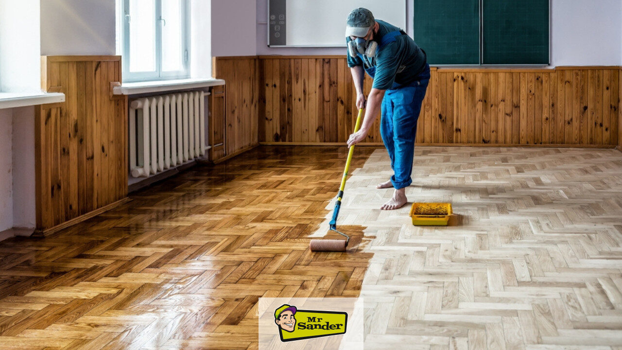 Restoring Hidden Parquet Floors—technician rolling finish on herringbone parquet, half coated.