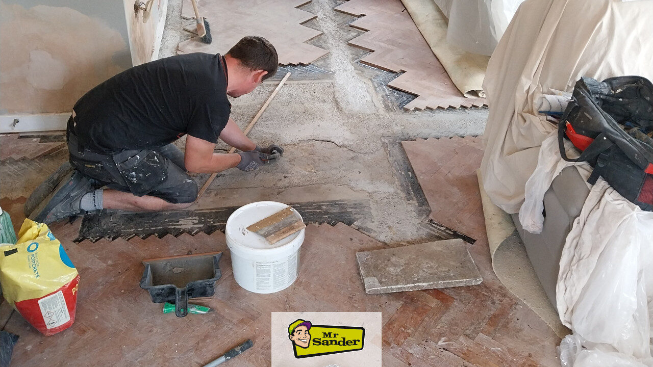 Revitalizing Your Parquet Flooring: specialist repairing subfloor and re-bedding loose herringbone parquet blocks before sanding and refinishing by Mr Sander