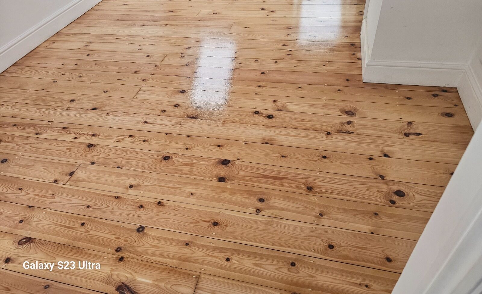 Sand Old Floorboards – pine floorboards (solid softwood) freshly sanded and sealed, showing a smooth satin finish with natural knots and grain.