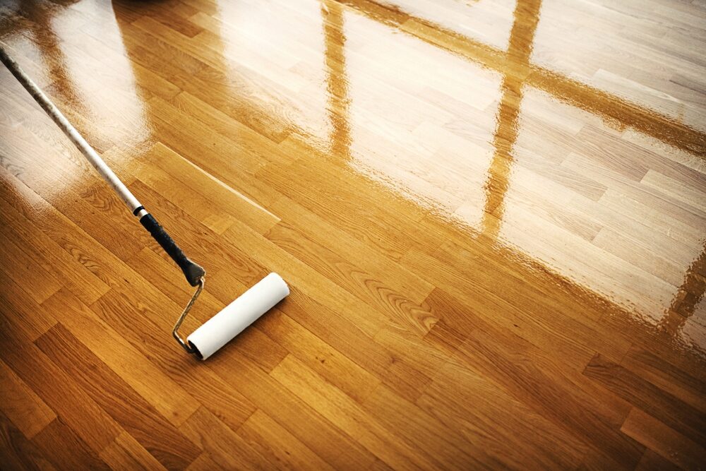 Sanding Hardwood Floors — applying water-based lacquer with a roller on oak parquet, wet-edge technique for an even sheen
