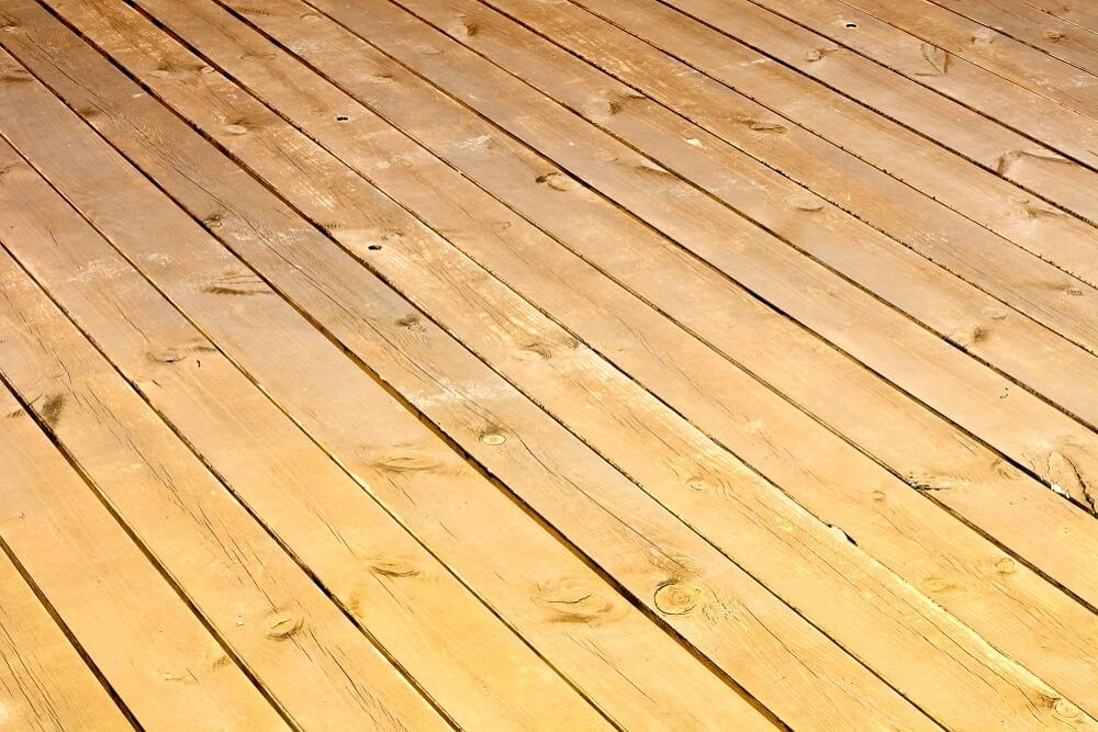A close-up view of a wooden floor with visible wear and scratches, highlighting the need for floor sanding and refinishing by Mr Sander®.