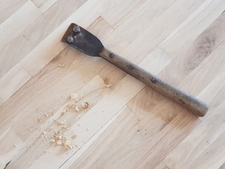 Hand,Scraper,And,Wood,Shavings,On,An,Oak,Parquet,Floor