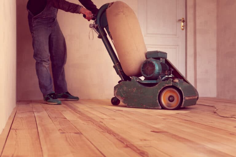 Carpenter,Polishes,A,Wooden,Floor,By,Electric,Grinding,Wood,Machine