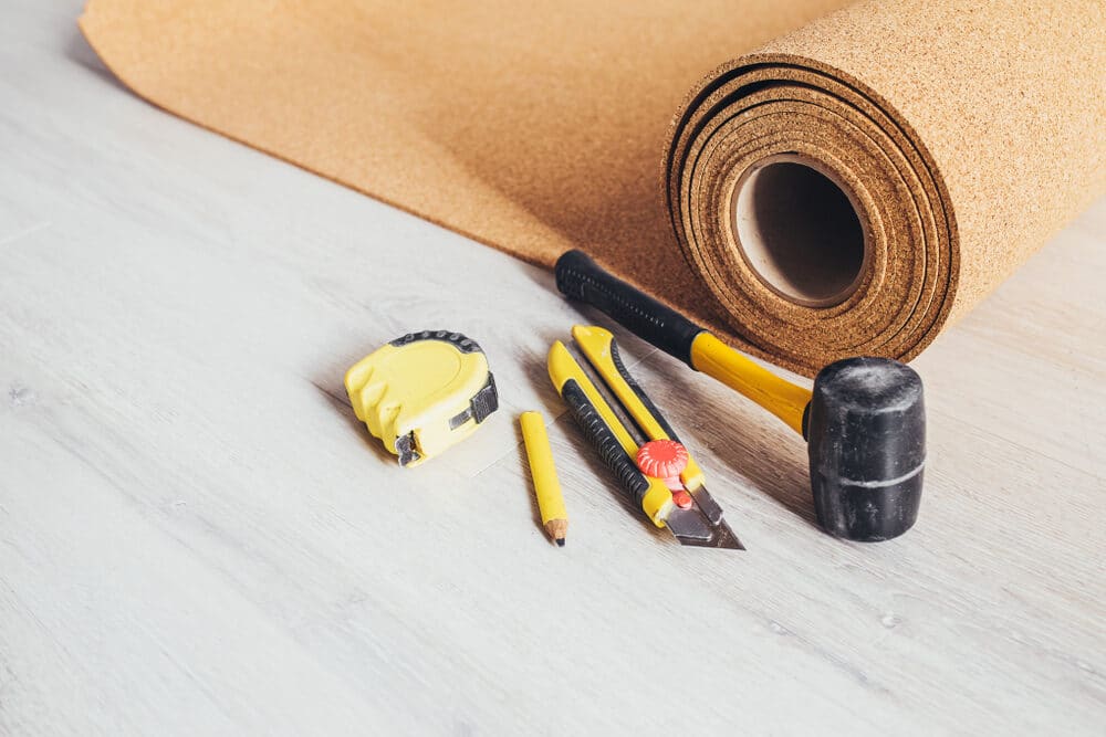 Flooring installation tools with a cork roll on a laminate surface