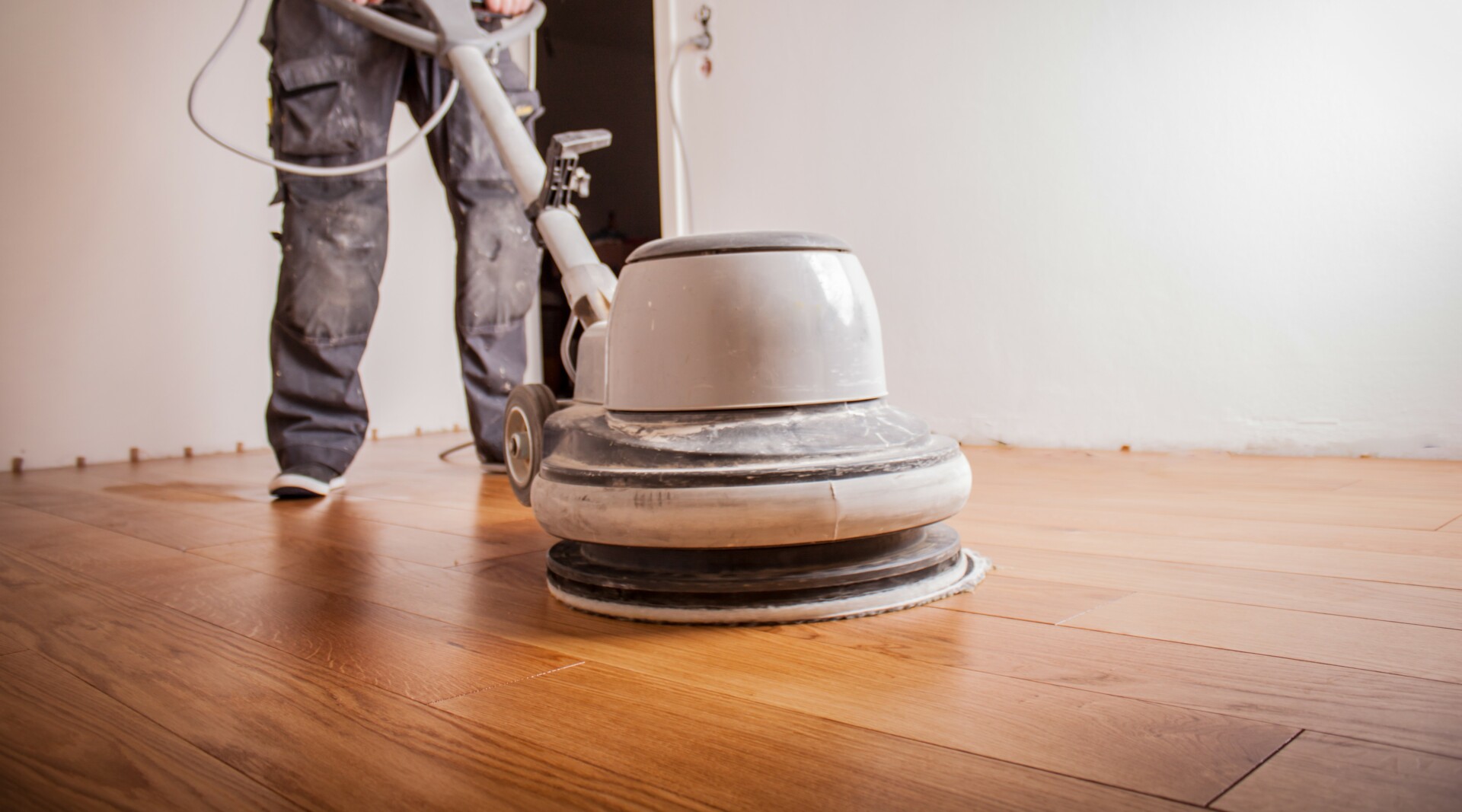 A floor buffing machine on polished wooden flooring.