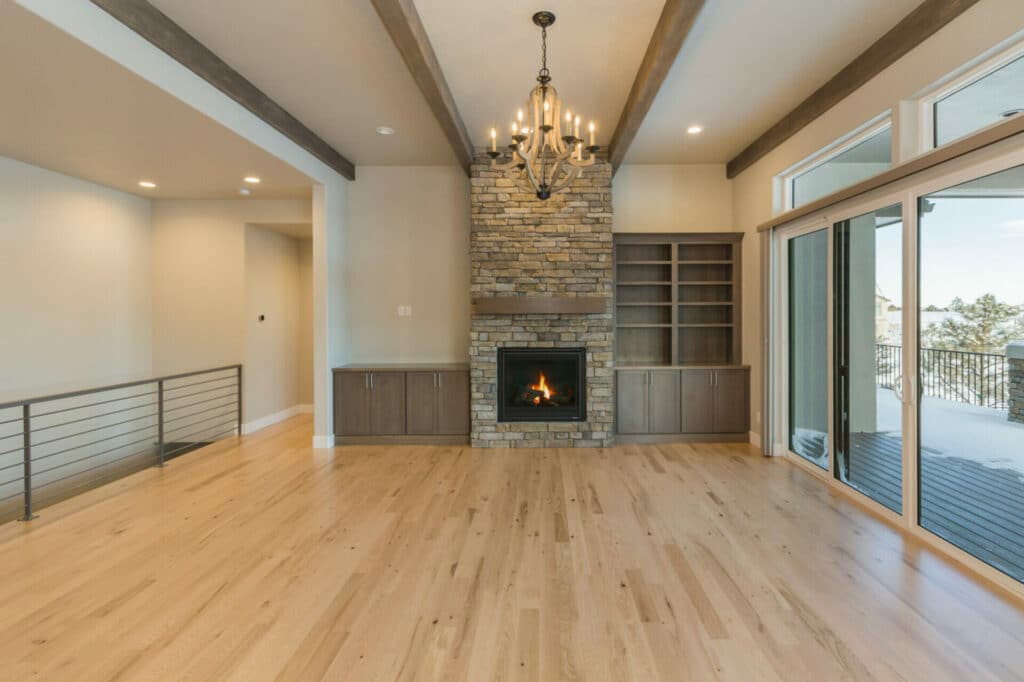 A modern living room with hardwood floors, a fireplace, and a view of the outdoors.