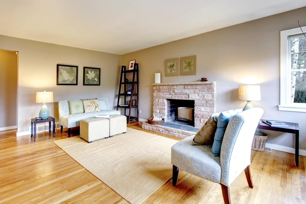 Cozy living room in Greater London (South West), UK featuring newly sanded and polished wooden floors by Mr Sander®, a brick fireplace, and elegant furnishings.