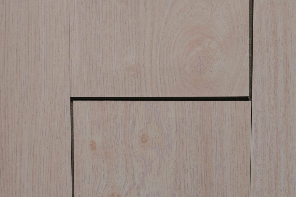 Close-up of pale wooden floor panels with visible grain and joints.