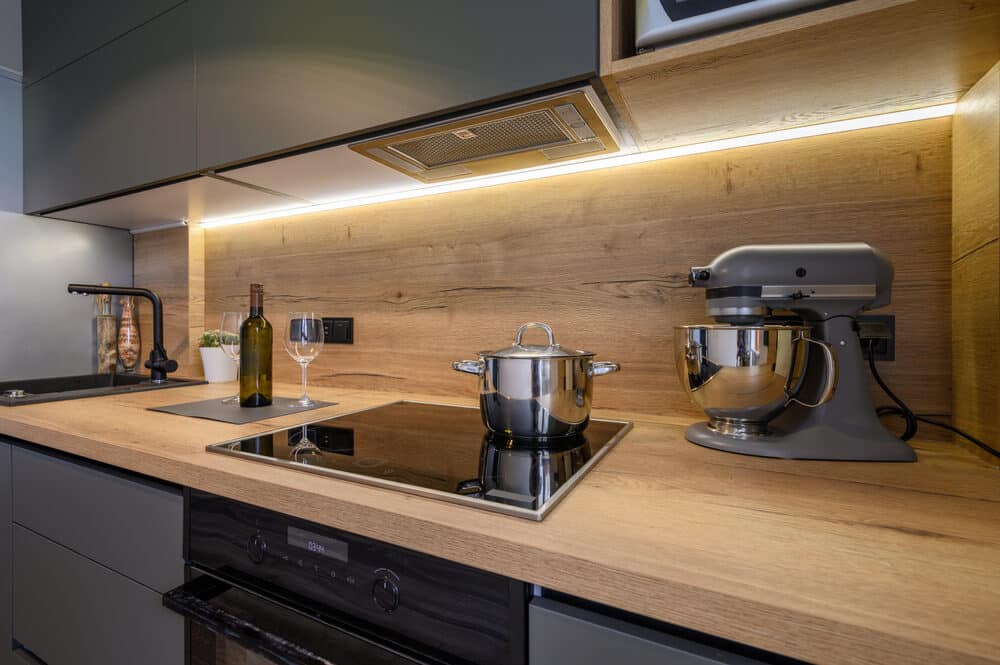 A stylish kitchen countertop with modern appliances, including a stand mixer and an induction stove.