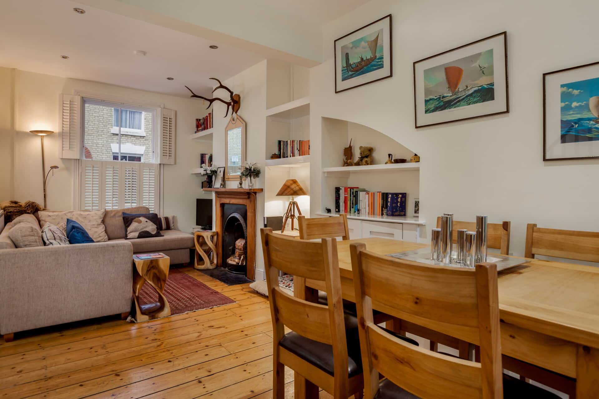Cozy living and dining area with beautifully refinished wooden floors, modern decor, and a fireplace.