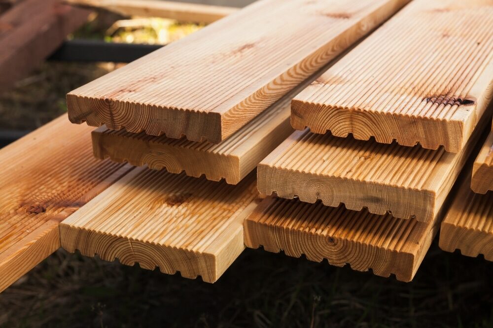 Stack of freshly cut wooden boards with interlocking edges.