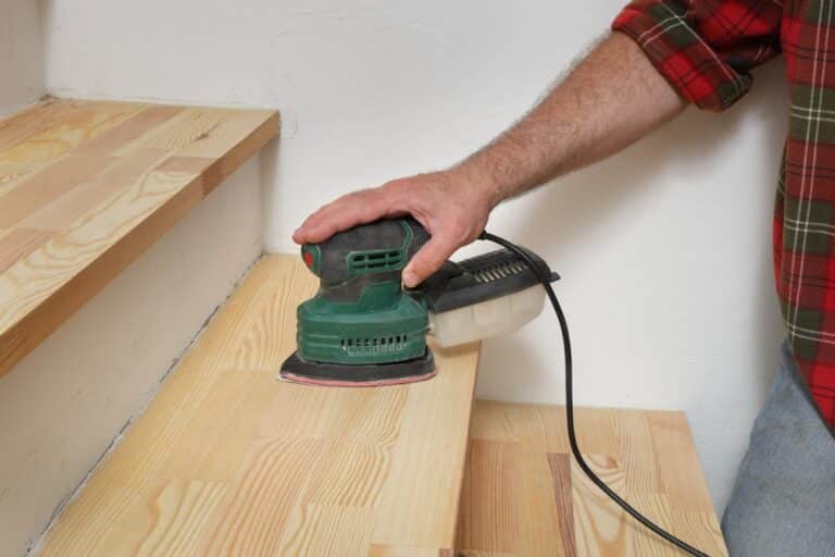 Closeup,Of,Worker,Hand,Sanding,Wooden,Stairs,Using,Powertool
